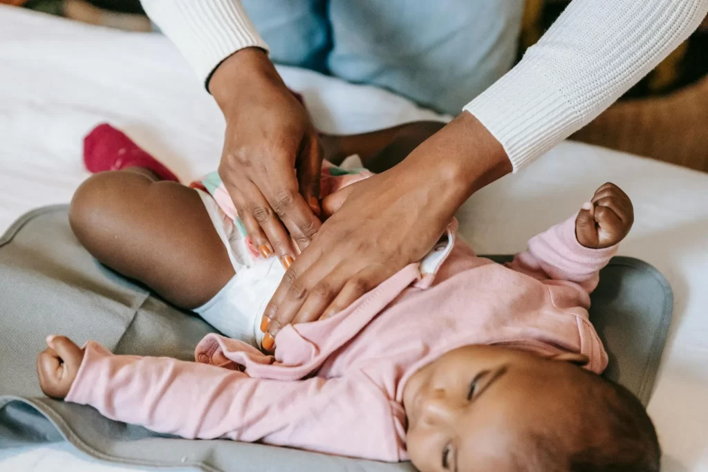 A mother changing her baby's diaper in public