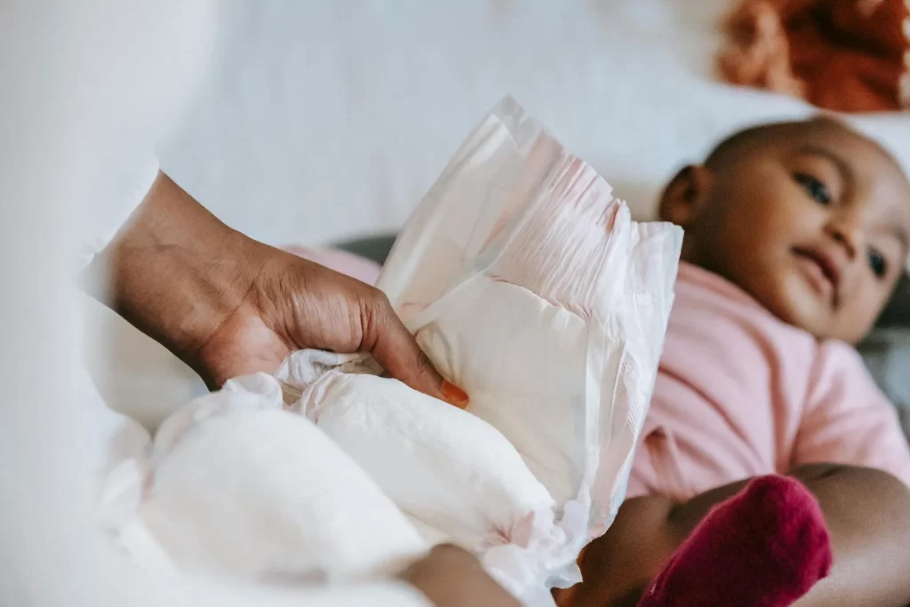 Una madre cambiando el pañal de su bebé sin un cambiador universal
